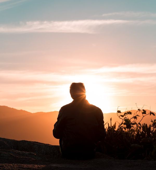 Silhouette of a person meditating against a beautiful sunset.